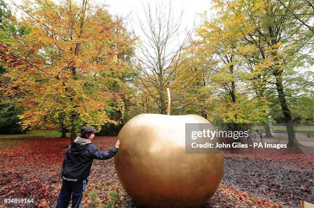 Visitor admires Pomme de New York by Claude Lalanne in the grounds of Chatsworth House in the Peak District.