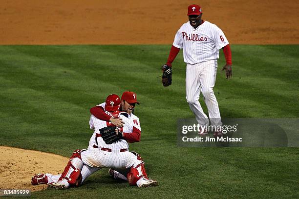 Brad Lidge and Carlos Ruiz of the Philadelphia Phillies hug as Ryan Howard runs towards them to celebrate their 4-3 win to win the World Series...