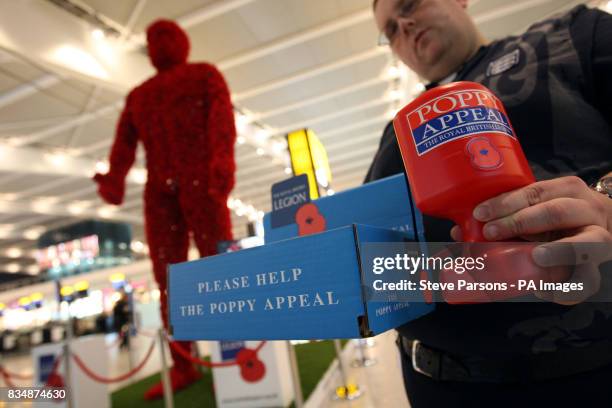 Metre tall 'Poppy Man' in the departures area of Terminal 5 at Heathrow Airport.