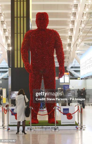 Metre tall 'Poppy Man' in the departures area of Terminal 5 at Heathrow Airport.