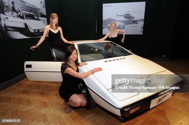 Bonhams' staff pose with the white 1976 Lotus Esprit from the 1977 Bond film, The Spy Who Loved Me, starring Roger Moore, on show at Bonhams in...