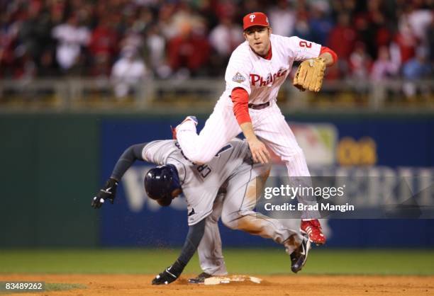 Carl Crawford of the Tampa Bay Rays slides to second base as Chase Utley of the Philadelphia Phillies turns a double play in the top of the eighth...