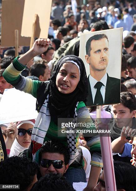 Syrian woman shouts slogans as another holds a portrait of Syrian President Bashar al-Assad during a demonstration in Damascus on October 30, 2008 to...