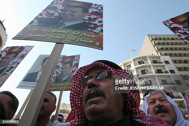Syrian man carries a portrait of Syrian President Bashar al-Assad during a demonstration in Damascus on October 30, 2008 to protest a deadly US raid...