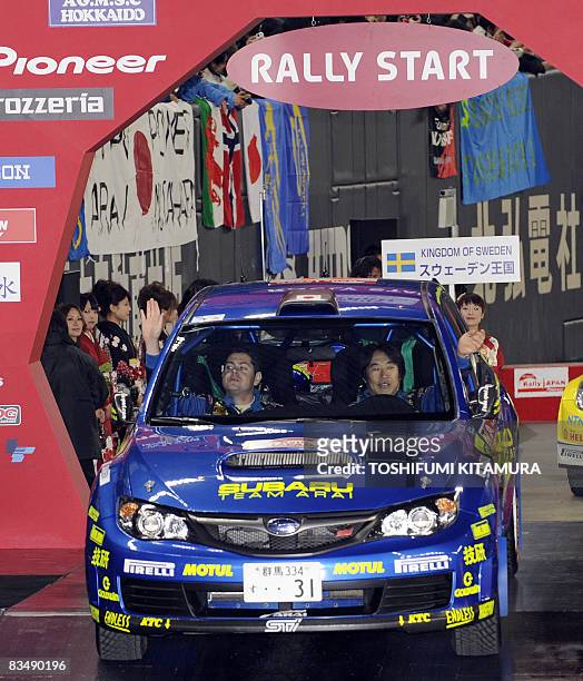 Japan's Toshi Arai and his co-driver Glenn MacNeall of Australia wave during the ceremonial start of the Rally Japan at the Sapporo Dome in Sapporo,...