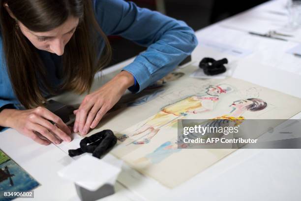 Restorer works on a drawing by German artist George Grosz from the collection of late German collector Cornelius Gurlitt during a press preview of...