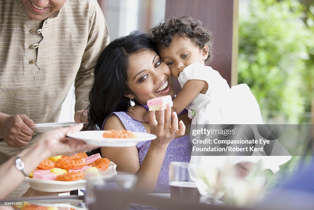 East Indian woman and child at family dinner.