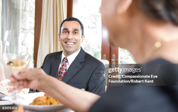 portrait of east indian man at dinner table - chink eye stock pictures, royalty-free photos & images
