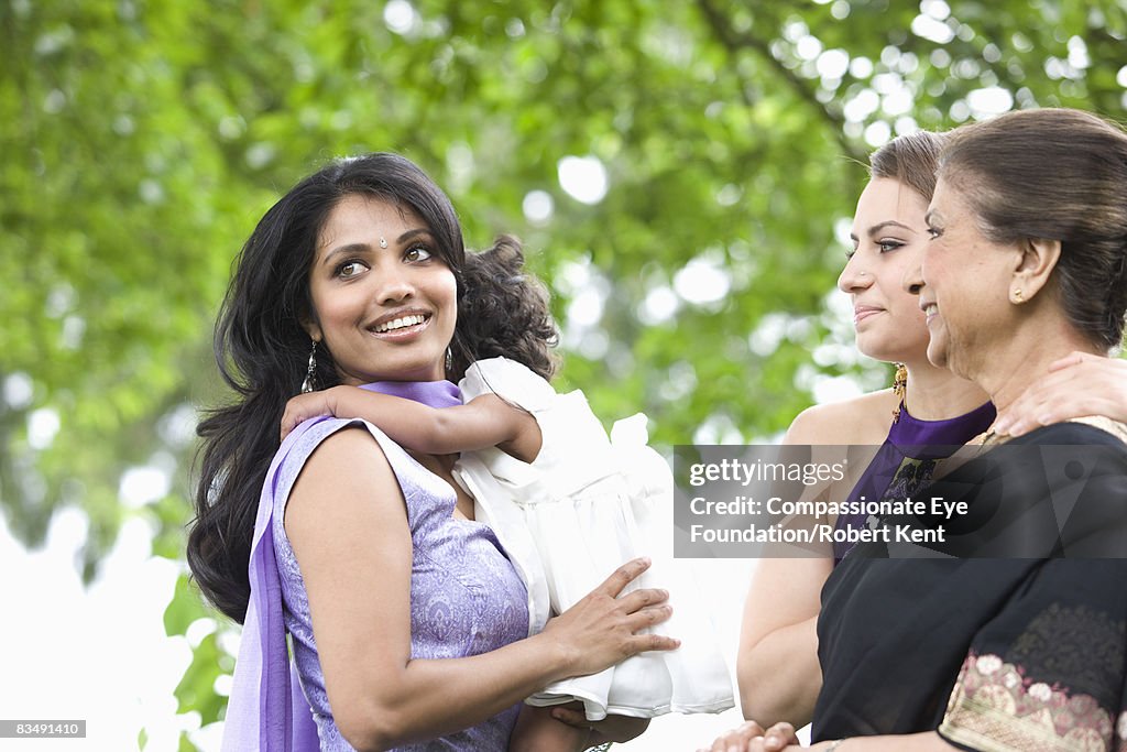 Group of East Indian Women holding a baby.