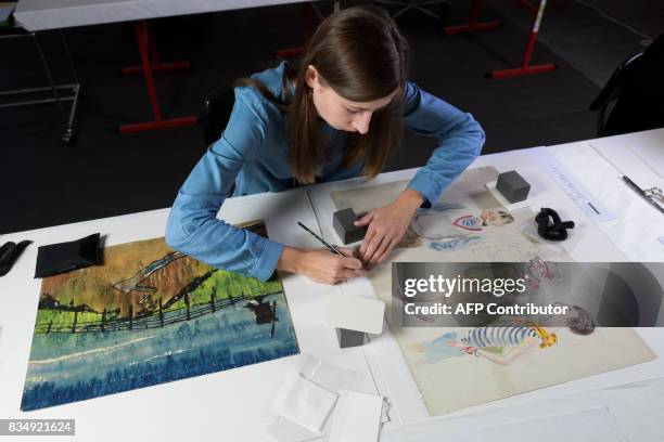 Restorer works on a drawing by German artist George Grosz from the collection of late German collector Cornelius Gurlitt during a press preview of...