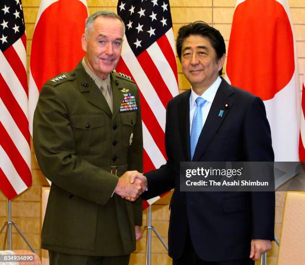 General Joseph Dunford, chairman of the U.S. Joint Chiefs of Staff and Japanese Prime Minister Shinzo Abe shake hands during their meeting at Abe's...