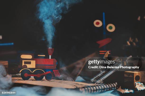 handcrafted paper train on a desk with notes and rulers. kid engineer workplace. - papercraft stock pictures, royalty-free photos & images