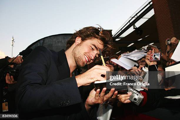 Actor Robert Pattinson signs autographs for the fans while attending the 'Twilight' Premiere during the 3rd Rome International Film Festival held at...