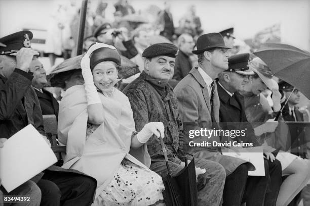 Queen Elizabeth II and others feel the downdraft from a helicopter at Winnipeg during a royal tour of Canada, July 1970.