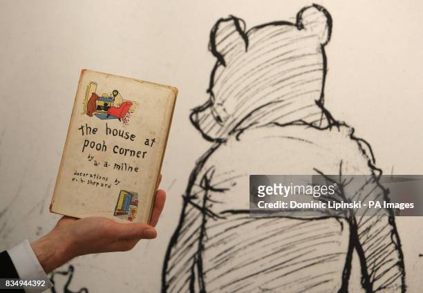 Member of staff at Sotheby's auction house holds a first American edition of 'The House at Pooh Corner', by AA Milne, dating from 1928, part of a...