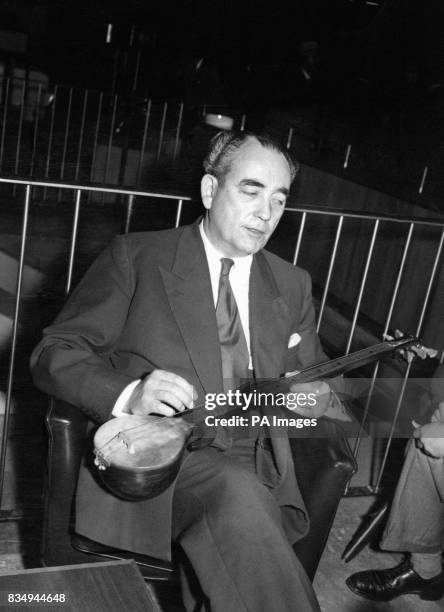 Tom Driberg, former Socialist Member of Parliament for Malden, Essex, with a r'bab, a Russian musical instrument, which he brought back to London...