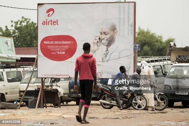 Pedestrians stand beside an advertisement for Bharti Airtel Ltd. In N'Djamena, Chad, on Tuesday, Aug. 15, 2017. African Development Bank and nations...