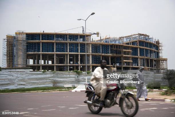 Motorcyclist passes the Cit des Affaires de N'Djamena construction site in N'Djamena, Chad, on Wednesday, Aug. 16, 2017. African Development Bank and...