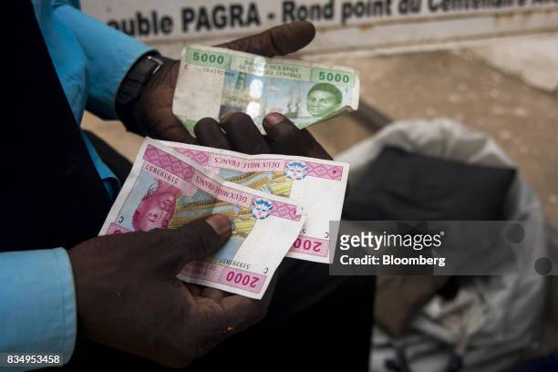Man counts out Central African franc banknotes on a street in N'Djamena, Chad, on Wednesday, Aug. 16, 2017. African Development Bank and nations...