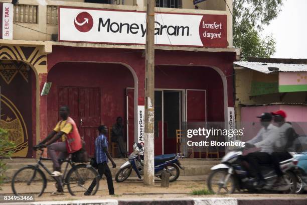 Pedestrians pass a MoneyGram International Inc. Money transfer store in N'Djamena, Chad, on Wednesday, Aug. 16, 2017. African Development Bank and...
