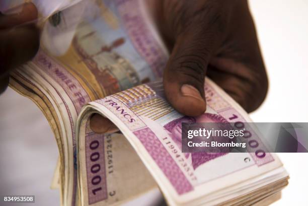 Man counts 10,000 denomination Central African franc banknotes in this arranged photograph in N'Djamena, Chad, on Wednesday, Aug. 16, 2017. African...