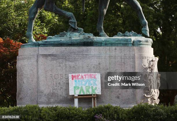 Homemade sign that says Heather Heyer Park rests at the base of the statue of Confederate Gen. Robert E. Lee that stands in the center of...