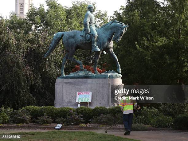 Homemade sign that says Heather Heyer Park rests at the base of the statue of Confederate Gen. Robert E. Lee that stands in the center of...