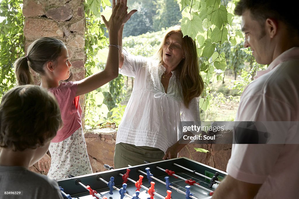 Tres generaciones familia jugando al fútbol de mesa