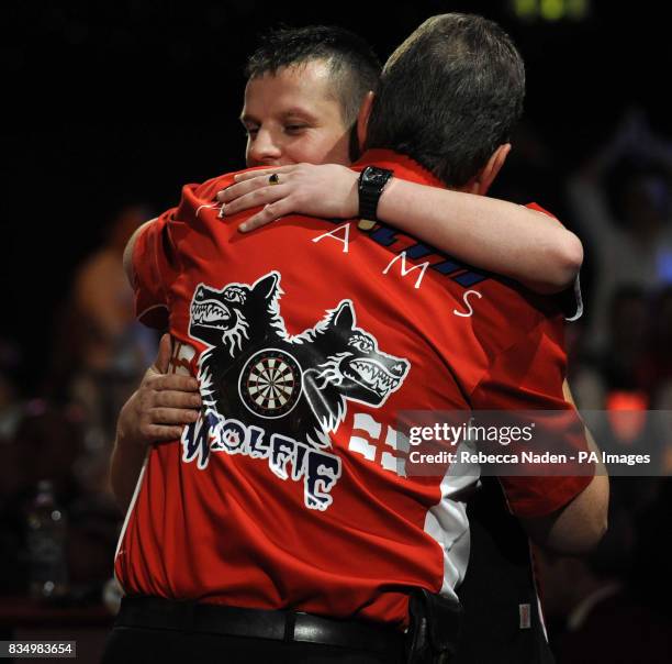 England's Martin Adams is congratulated by Dave Chisnall during the World Darts Championship at Frimley Green, Surrey.