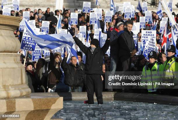 Pro-Palestinian protester gestures as he stands in front of pro-Israeli demonstrators at a pro-Israel rally in Trafalgar Square, London.