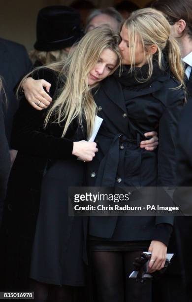 Olivia and Arabella, the daughters Sir Dai Llewellyn, comfort each other at their fathers funeral at St Marys Church, Coddenham, Suffolk.