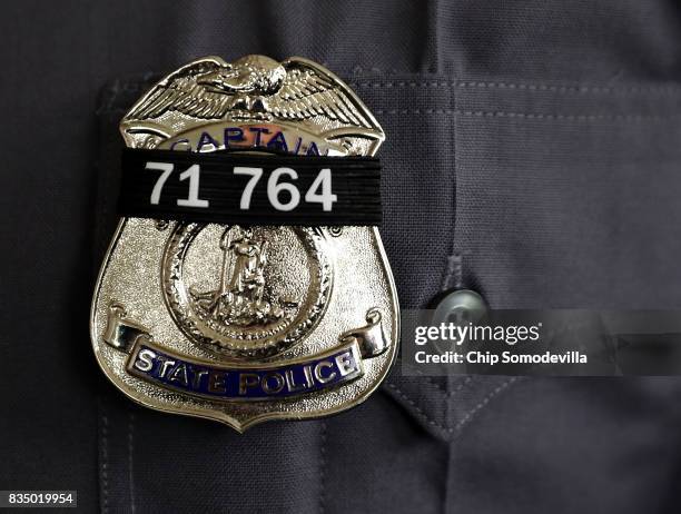 Black band with the badge number of Virginia State Police Trooper-Pilot Berke M.M. Bates is worn on the badges of fellow troopers during his funeral...