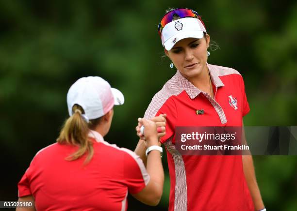 Cristie Kerr and Lexi Thompson of Team USA bump fists during the morning foursomes matches of The Solheim Cup at Des Moines Golf and Country Club on...