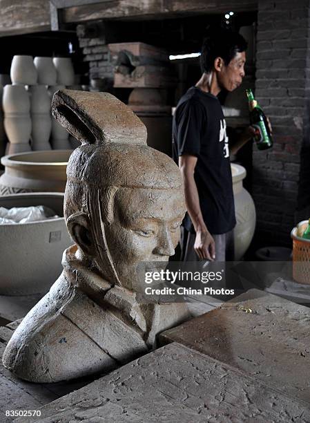 Worker drinks beer amongst pottery products at the Ancient Nanfeng which was built up in Ming Dynasty , on October 28, 2008 in Foshan of Guangdong...