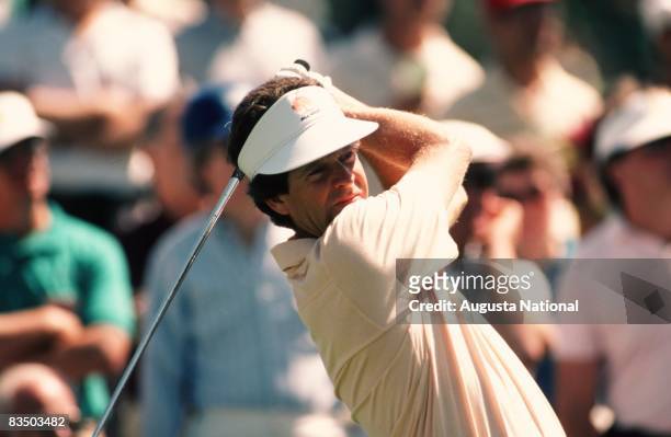 Bob Tway watches his shot from the finish position in front of a small gallery during the 1986 Masters Tournament at Augusta National Golf Club in...
