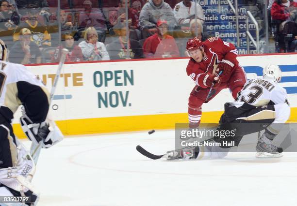 Shane Doan of the Phoenix Coyotes shoots the puck past Alex Goligoski of the Pittsburgh Penguins during an NHL game at Jobing.com Arena October 30,...