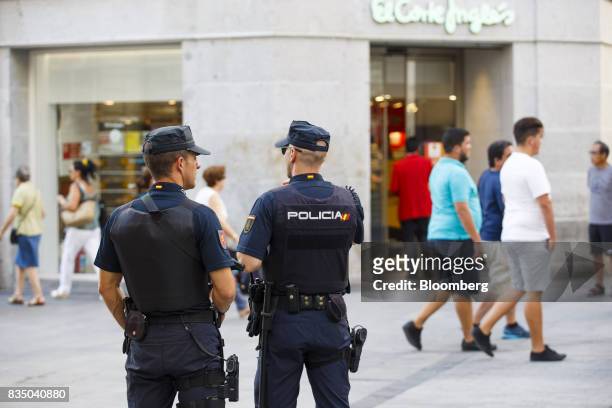 Armed police officers patrol a pedestrian shopping area outside the El Corte Ingles SA department store on Preciados street in Madrid, Spain, on...