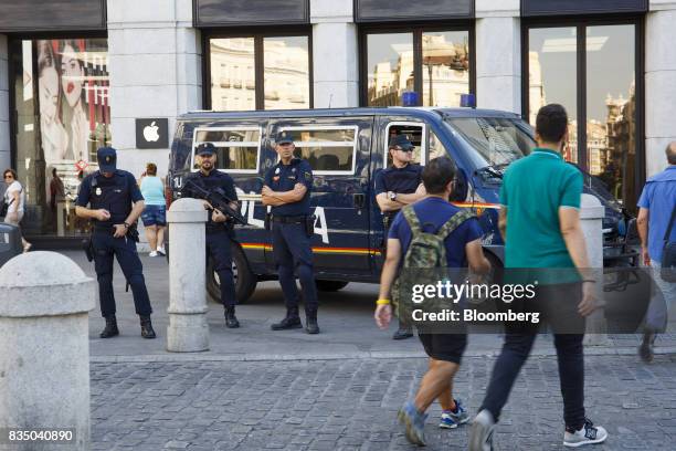 Armed police officers watch shoppers pass by the Apple Inc. Store in Madrid, Spain, on Friday, Aug. 18, 2017. Terrorists behind the Barcelona attack...