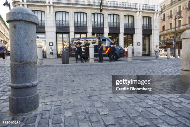 Armed police officers watch shoppers pass by the Apple Inc. Store in Madrid, Spain, on Friday, Aug. 18, 2017. Terrorists behind the Barcelona attack...