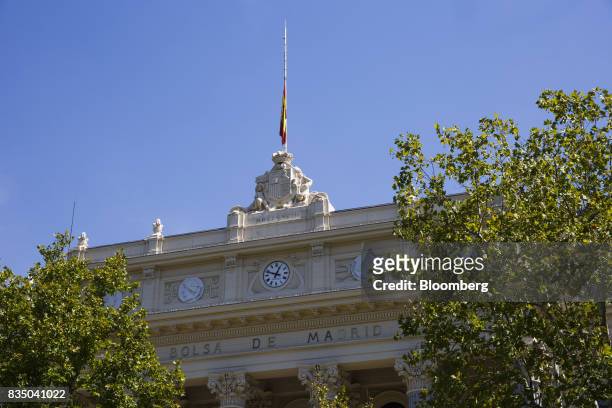 The Spanish national flag flies at half staff above the Madrid stock exchange, also known as Bolsas y Mercados Espanoles, following the Barcelona...