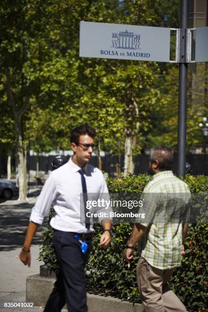 Pedestrians pass a sign outside the Madrid stock exchange, also known as Bolsas y Mercados Espanoles, the day after the Barcelona terror attack in...