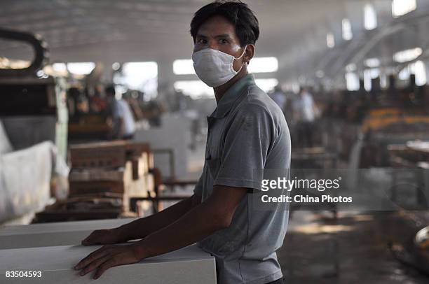Worker wearing a mask rests at a tile product line in a workshop of Monalisa Ceramics Company which was shifted from China's largest ceramics...