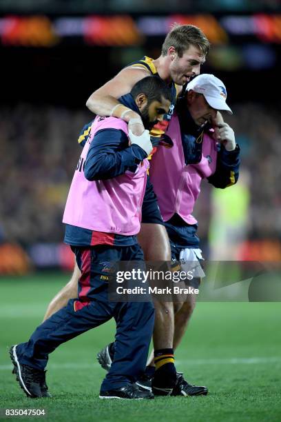 Daniel Talia of the Crows is helped off by crows trainers during the round 22 AFL match between the Adelaide Crows and the Sydney Swans at Adelaide...