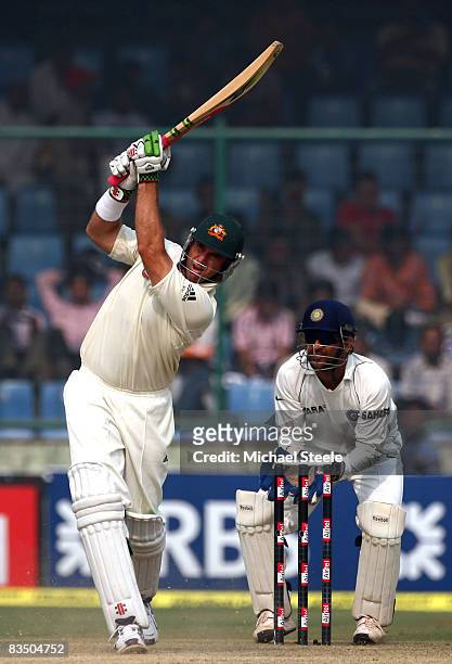 Matthew Hayden of Australia hits a four off the bowling of Amit Mishra watched by wicketkeeper MS Dhoni during day three of the Third Test match...