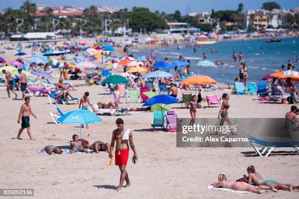 People enjoy the beach next to the spot where five terrorists were shot by police on August 18, 2017 in Cambrils, Spain. Fourteen people were killed...