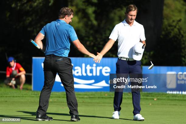 Paul Dunne of Ireland is is congratulated on his win by Jens Fahrbring of Sweden on the 15th green during the 32 qualifiers matches of the Saltire...