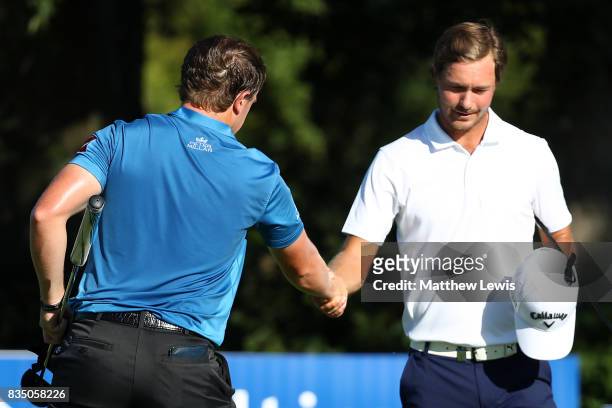 Paul Dunne of Ireland is is congratulated on his win by Jens Fahrbring of Sweden on the 15th green during the 32 qualifiers matches of the Saltire...
