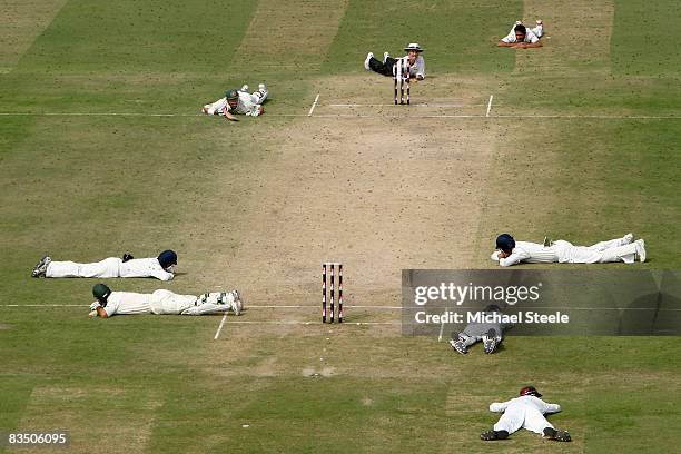 Ricky Ponting and Matthew Hayden of Australia lie on the ground along with the Indian players and umpire Billy Bowden as a swarm of bees pass over...