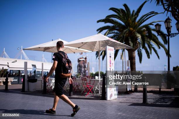 Tourist walks next to an empty bar terrace next to the spot where five terrorists were shot by police on August 18, 2017 in Cambrils, Spain. Fourteen...