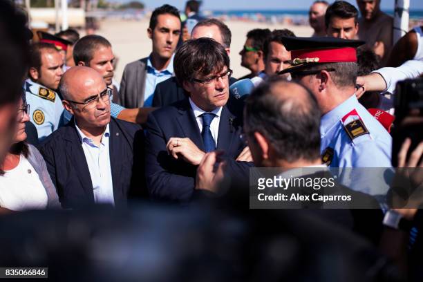 President of Catalonia Carles Puigdemont speaks with a police officer as he visits the spot where five terrorists were shot by police on August 18,...